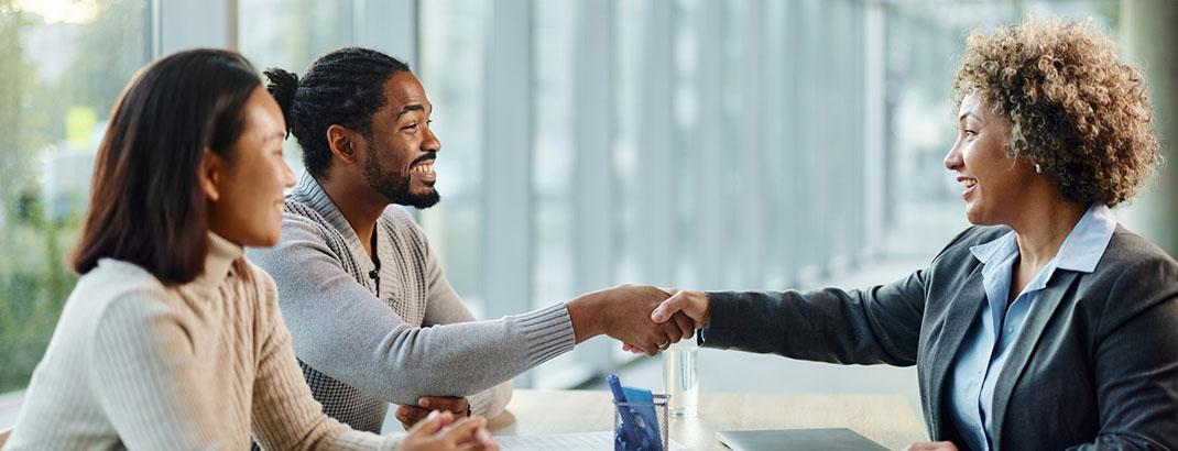 real estate agent shaking hands with young couple
